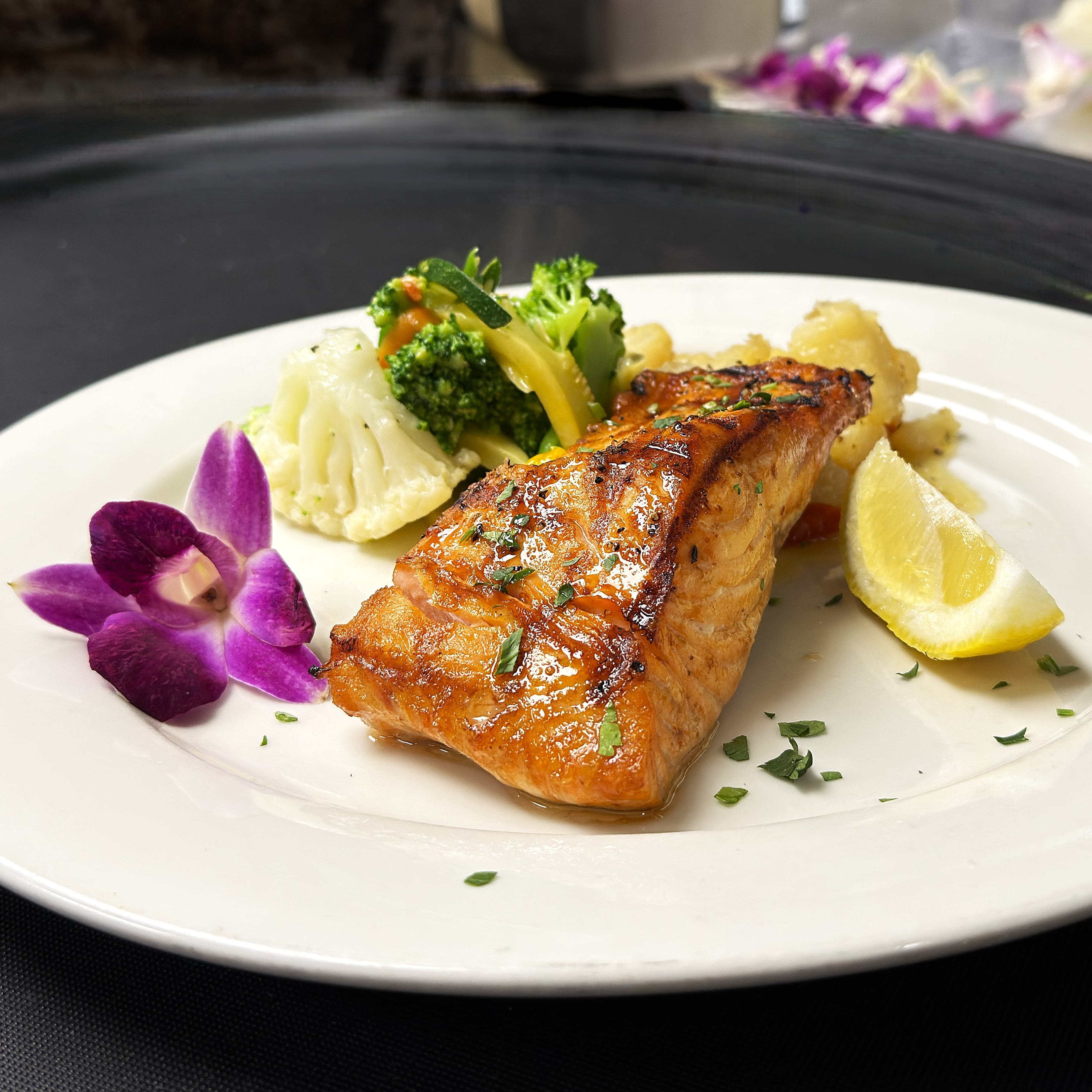 Glazed salmon fillet with seasonal vegetables and lemon